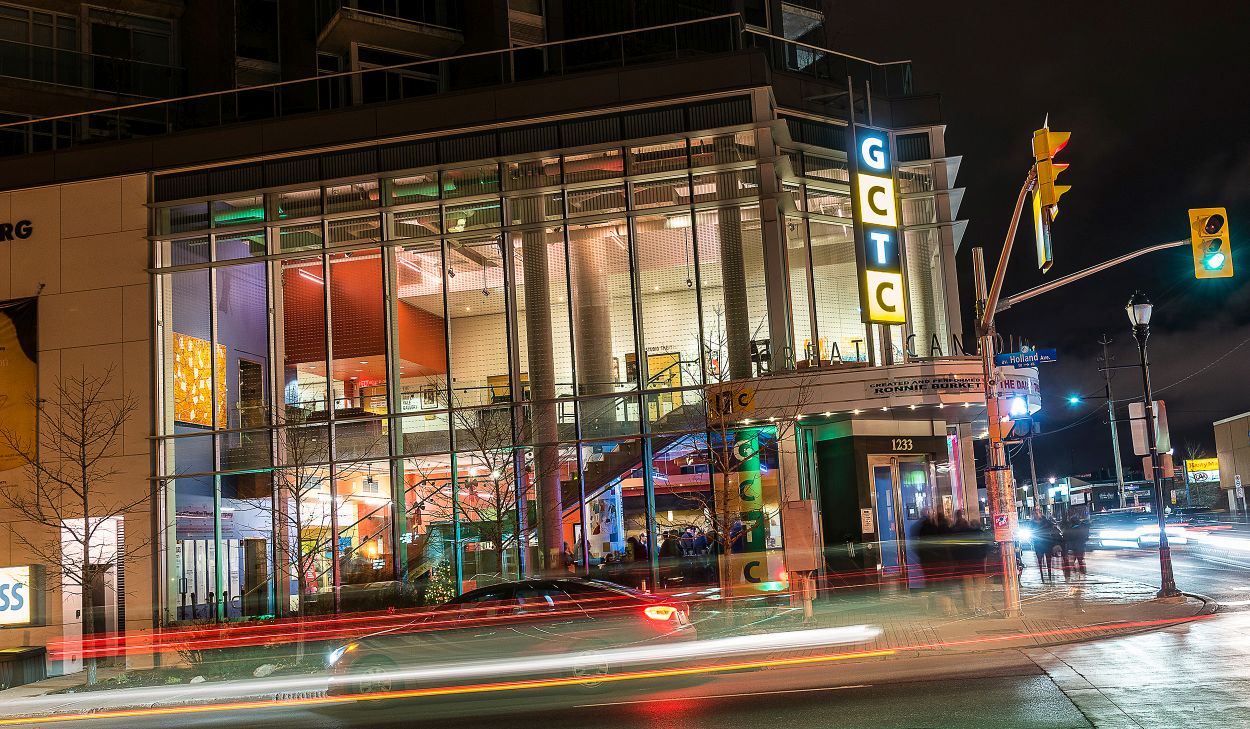 Exterior night view of the theatre featuring its multi coloured glass windows.