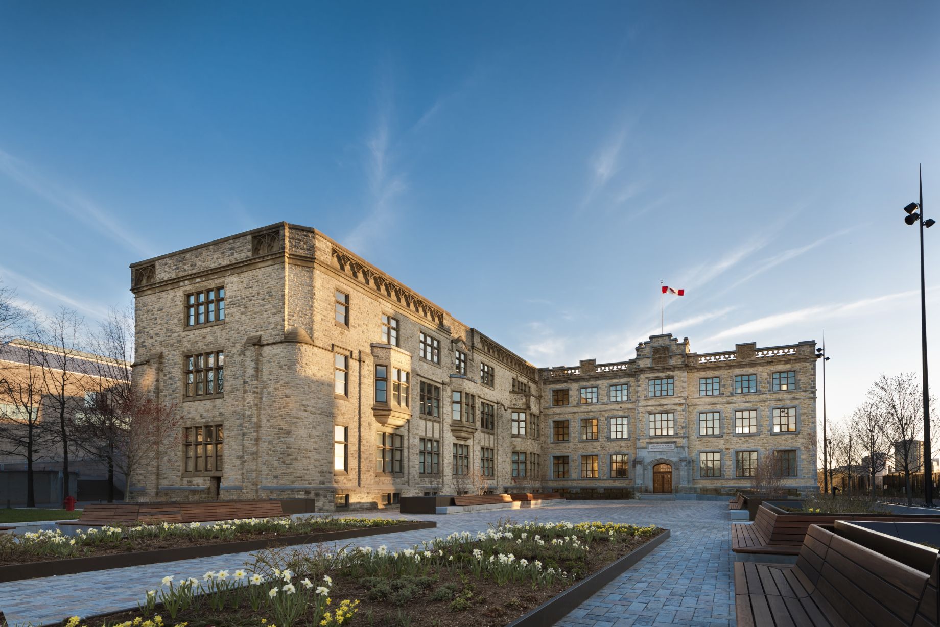 Exterior view of a fully restored, L-shaped, three-storey early 1900s stone building