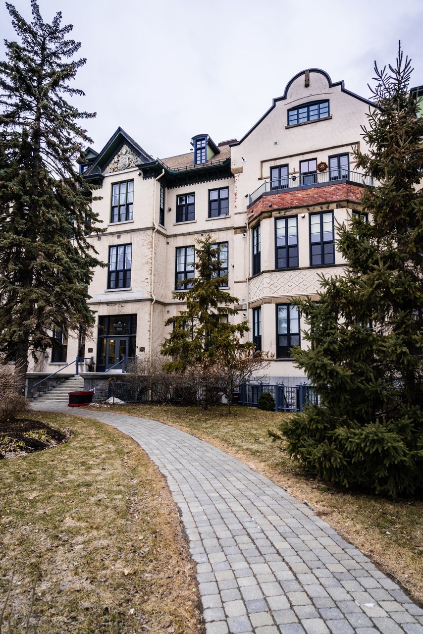 Exterior photo of the beige coloured five-storey former hospital built in 1873 that is now a high-end condo building.
