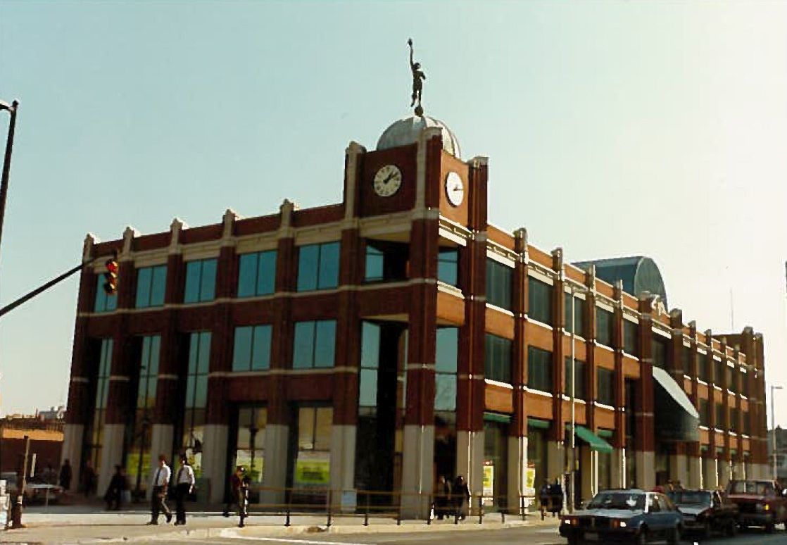 Exterior view of the three-storey brick Mercury Court building and the "Flying Mercury"weathervane.